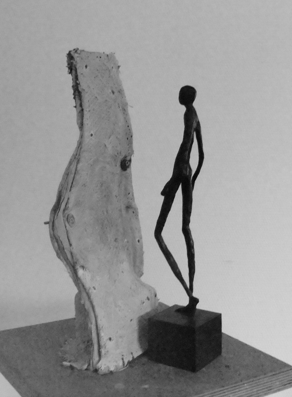 Bronze elegant slim figure standing next to its mold 