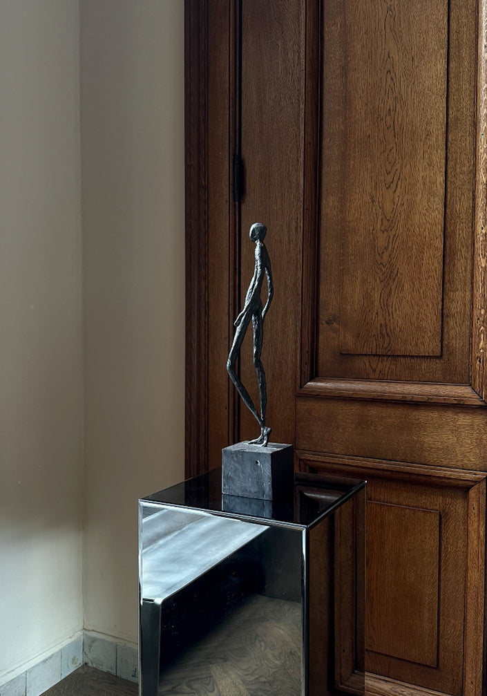Bronze Sculpture | Quiet Confidence: A slender bronze figure walking, mounted on a block, showcasing Dutch artist Veri Wisman's impressionistic charm. Handcrafted in the Netherlands.