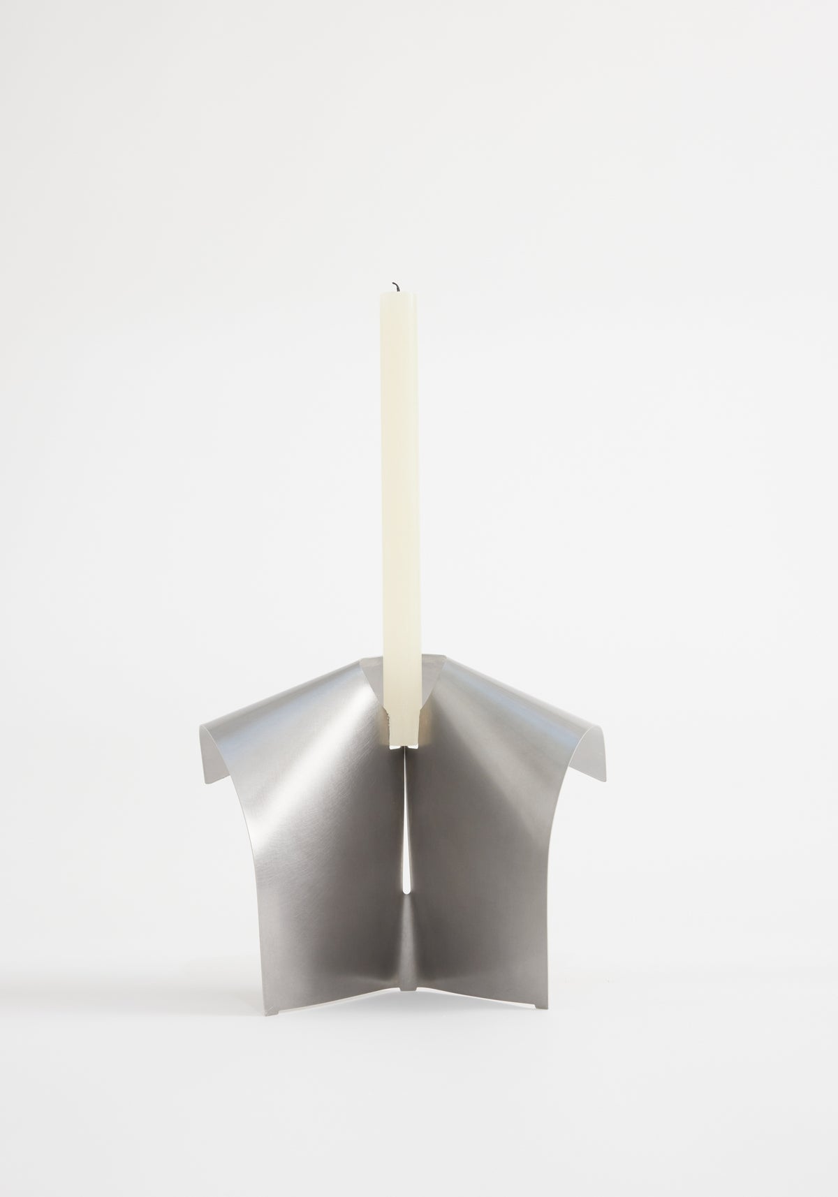 Minimalist stainless steel candle holder with a modern folded design holding a tall, slender white candle, Stainless steel candle holder | Stainless steel.