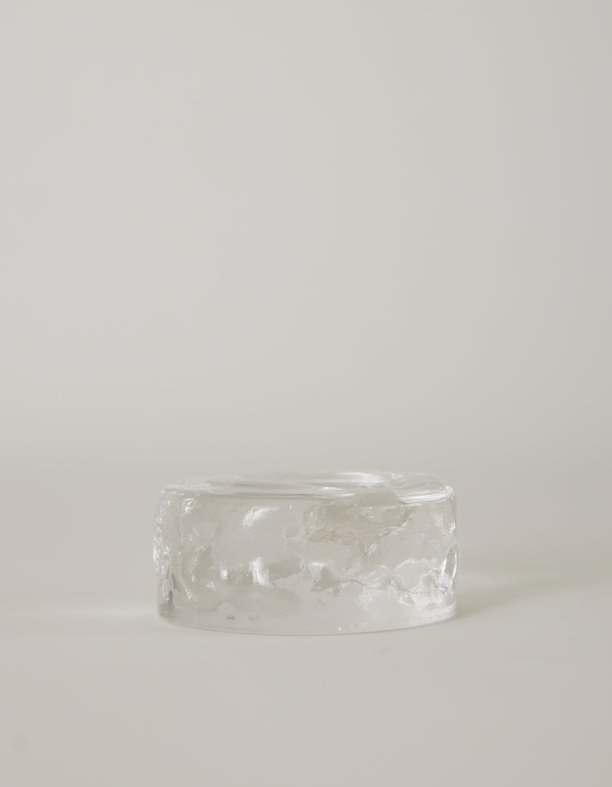 Presse-papier & holder: A translucent, low-profile glass cylinder with a rippled finish, resembling a minimalistic paperweight, handcrafted by Szkło Studio.