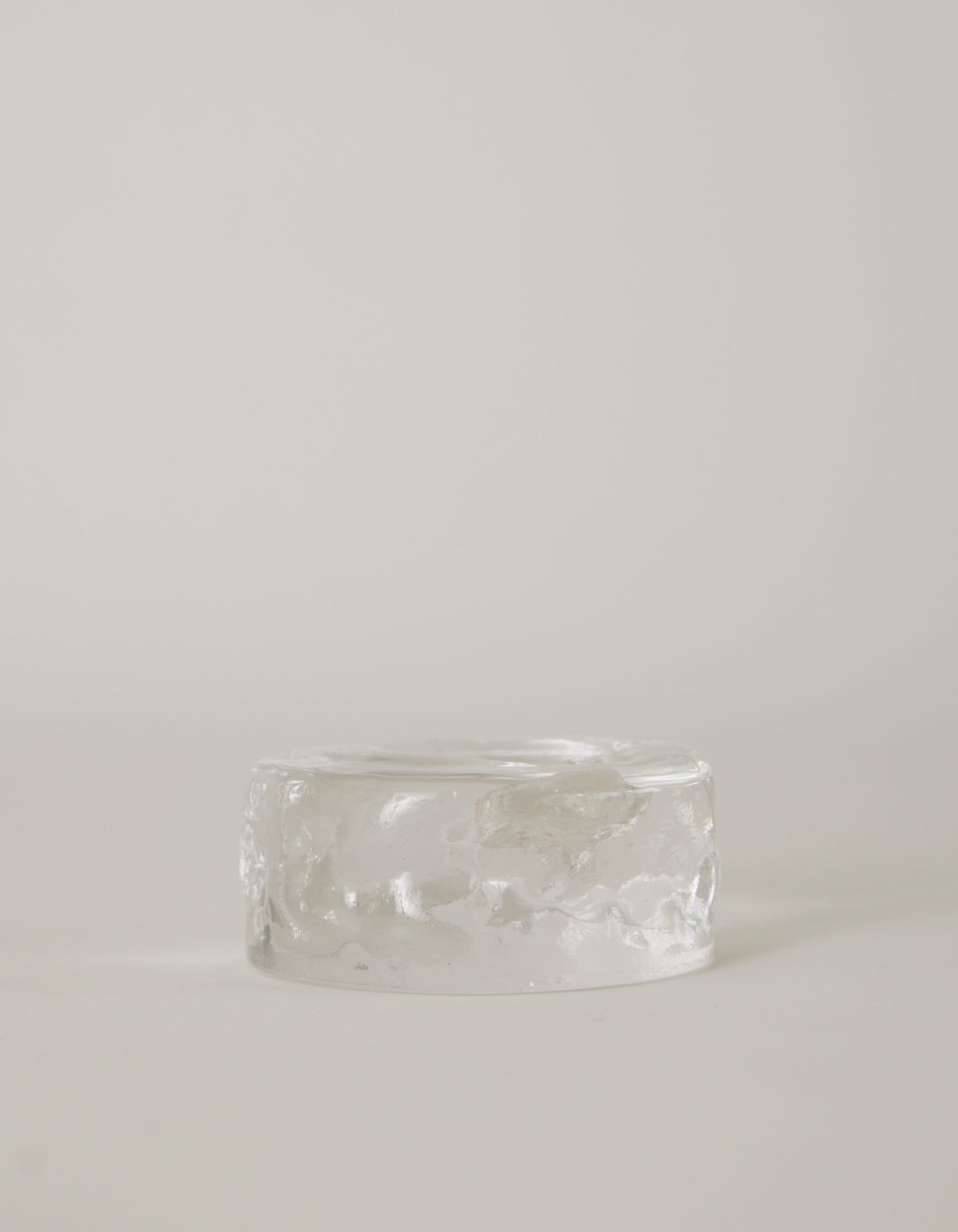Presse-papier & holder: A translucent, low-profile glass cylinder with a rippled finish, resembling a minimalistic paperweight, handcrafted by Szkło Studio.