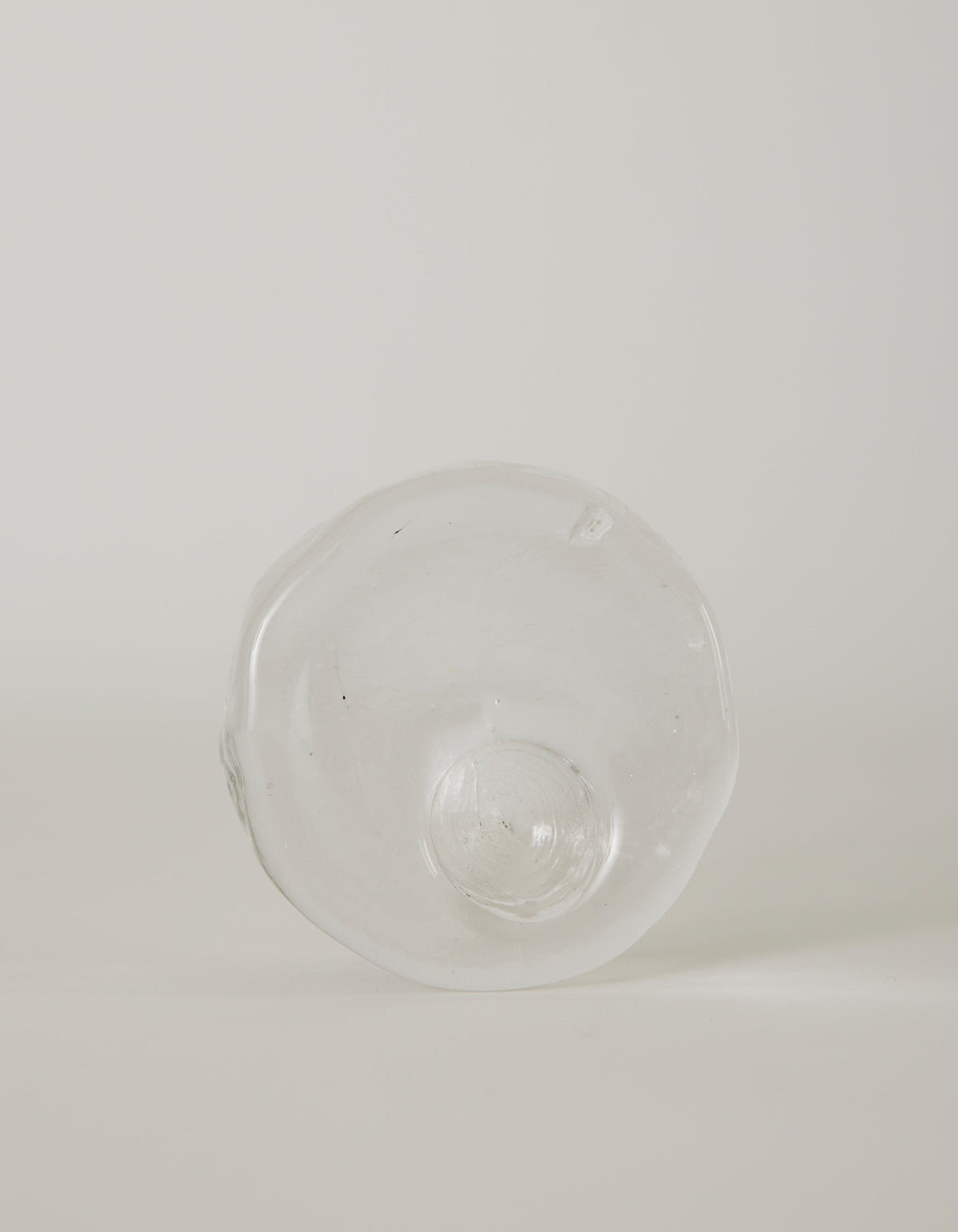 Presse-papier & holder | Glass: Hand-blown, transparent glass object with wavy edges and a central dome, showcasing Szkło Studio's unique, functional glass artistry.