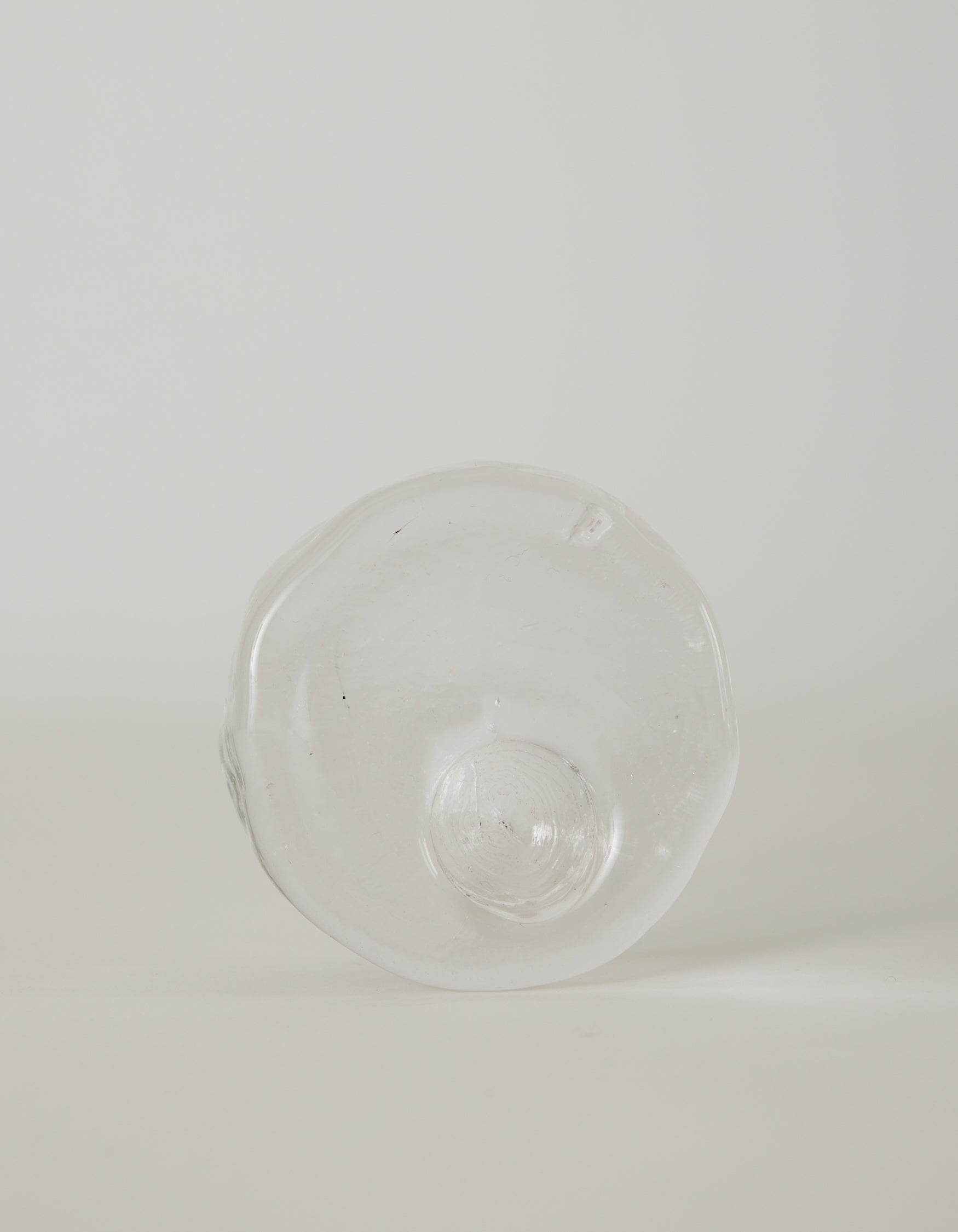 Presse-papier & holder | Glass: Hand-blown, transparent glass object with wavy edges and a central dome, showcasing Szkło Studio's unique, functional glass artistry.