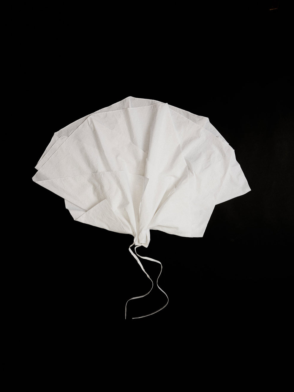 White cotton skirt in the shape of a fanned out flower on a black background