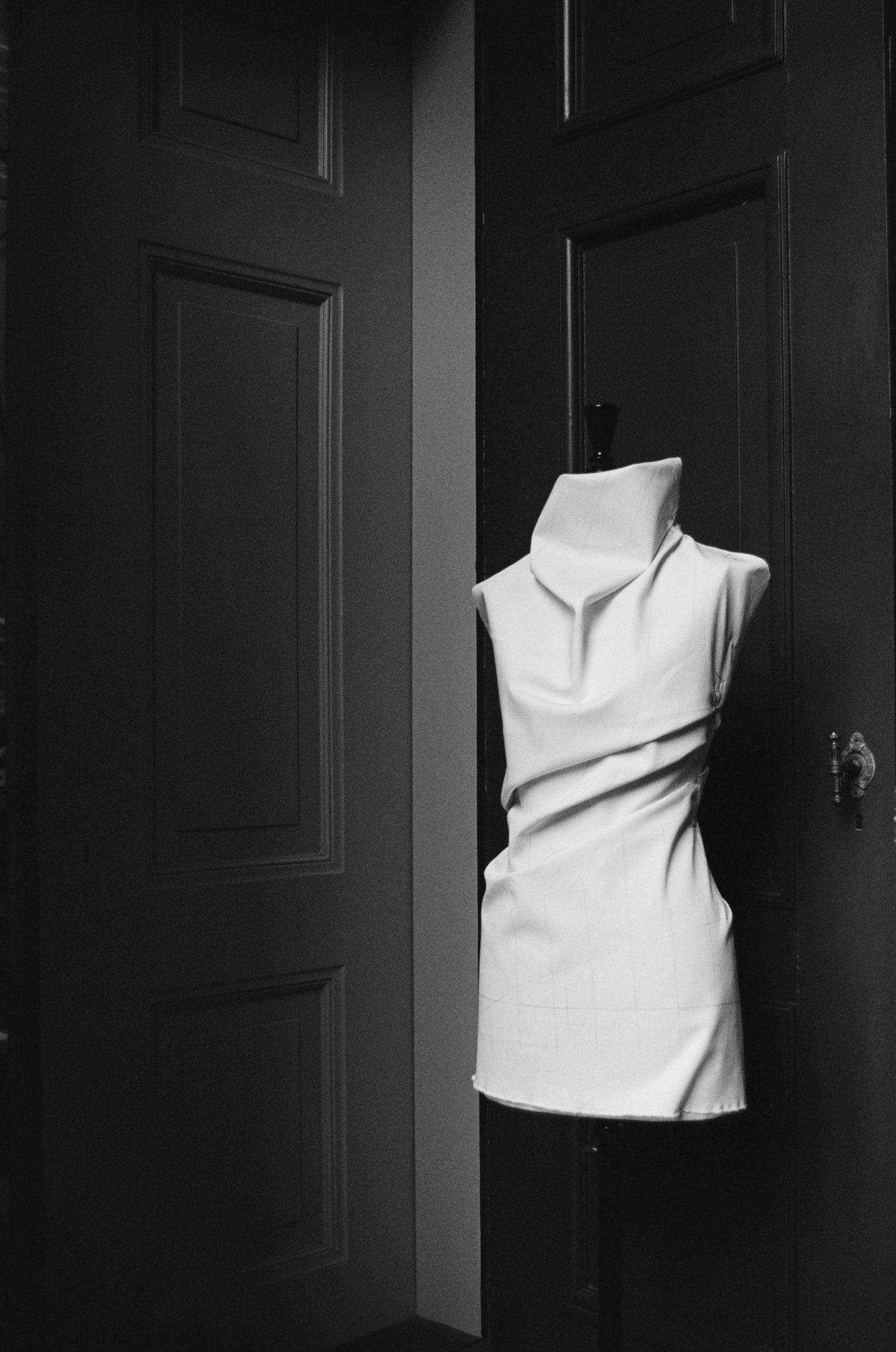 Mannequin with canvas fabric draped around it against a dark background