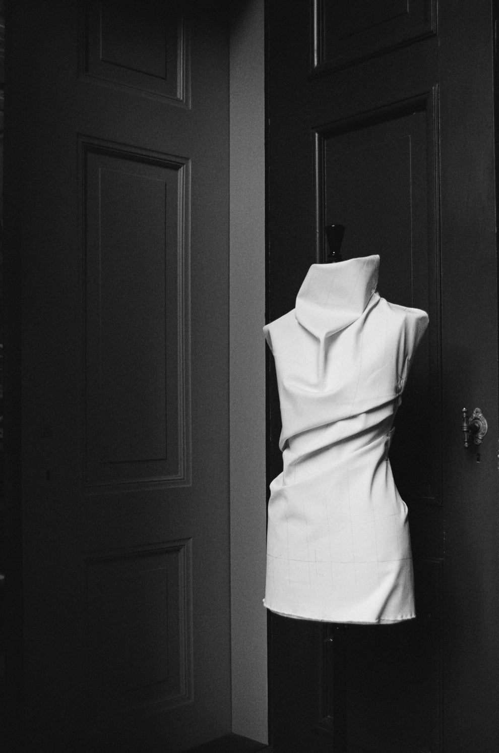 Mannequin with canvas fabric draped around it against a dark background