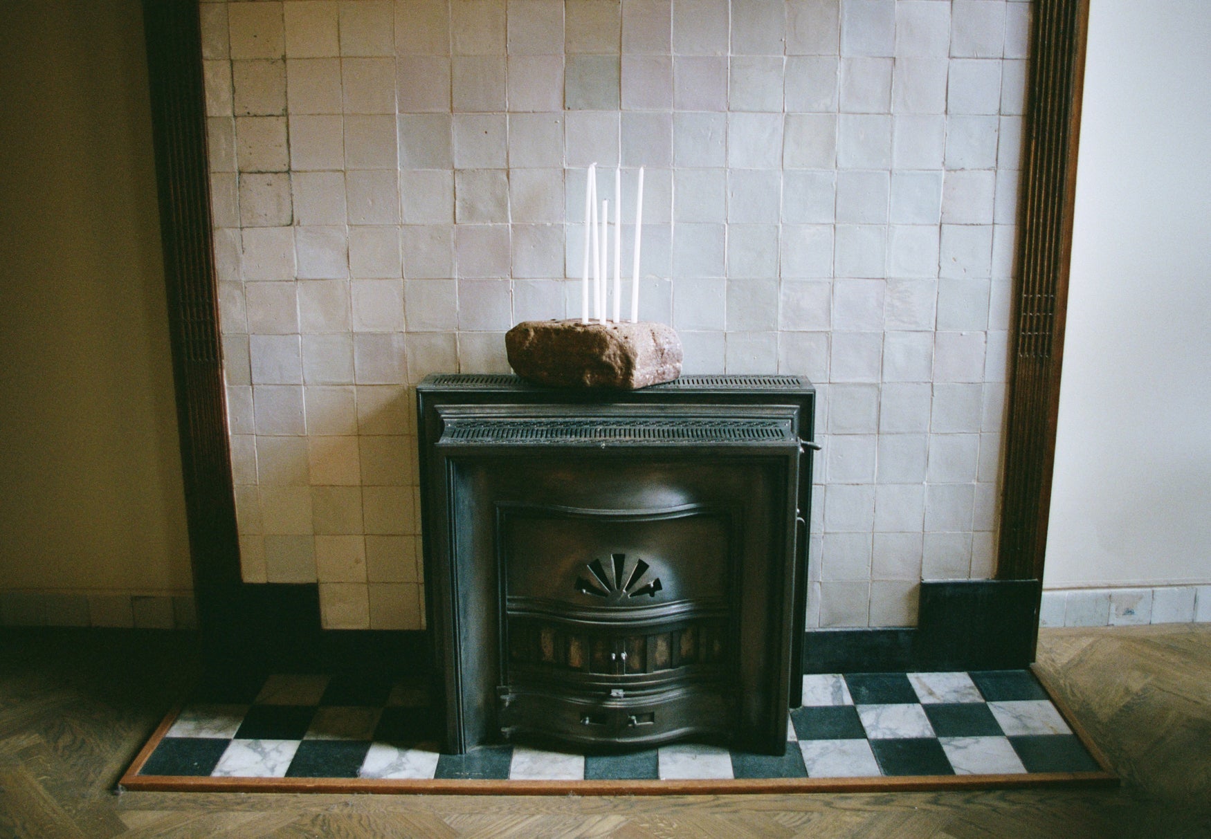 17th century fireplace with a tiled wall and checkered floor