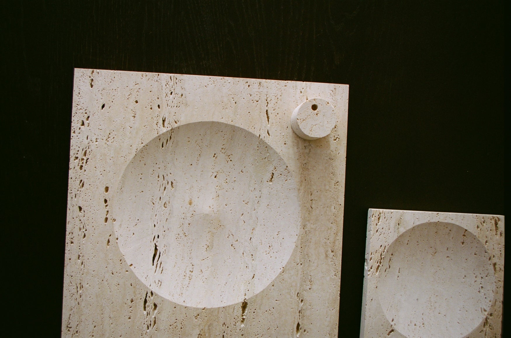 Large tray | travertine: Two rectangular travertine slabs, each with a circular indent, featuring a matching cylinder for candles, handcrafted by artist Louis Crombag.