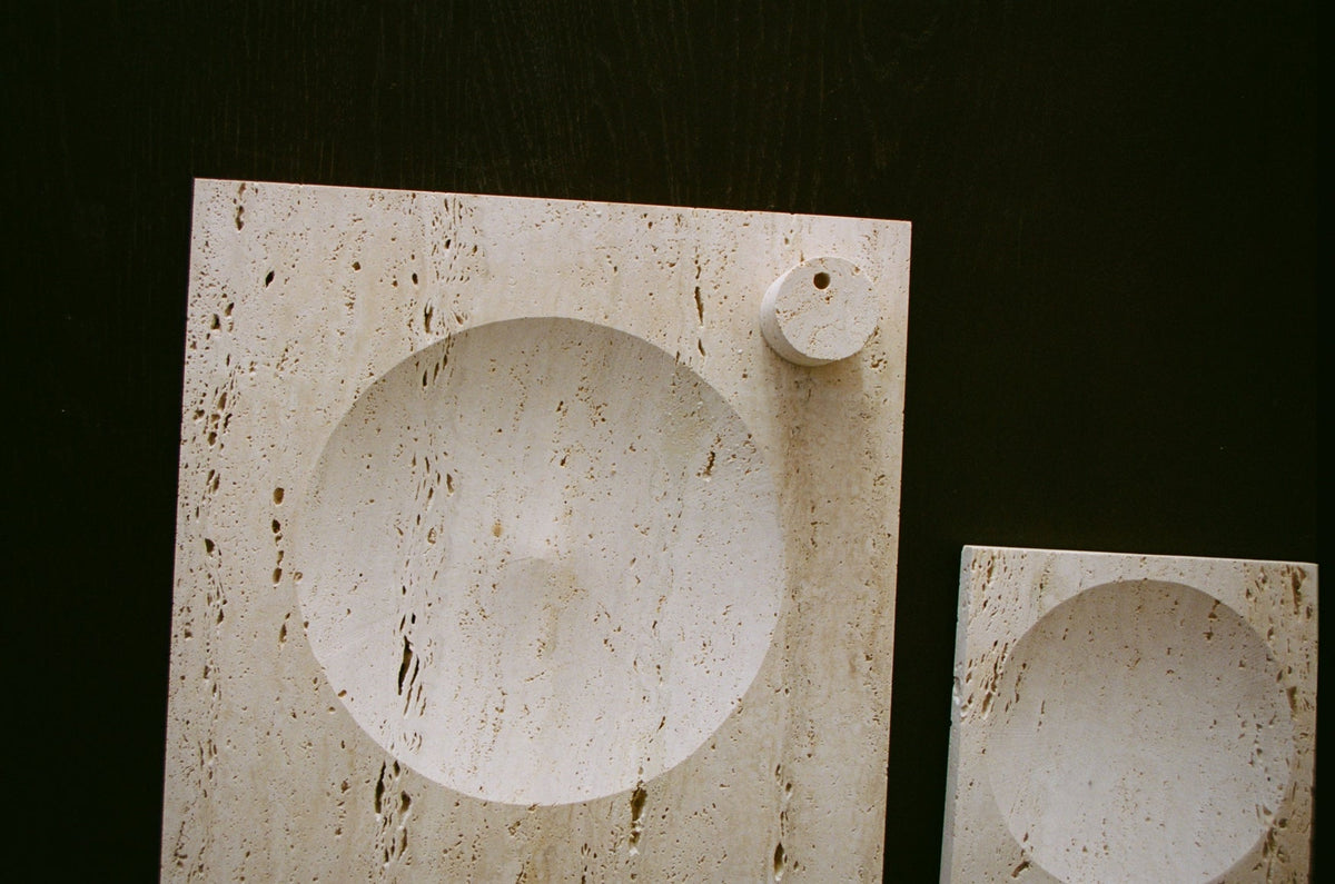 Small tray | travertine: Two light-beige travertine slabs feature a round, carved indent and a small circular relief, showcasing minimalistic, handcrafted design by Louis Crombag.