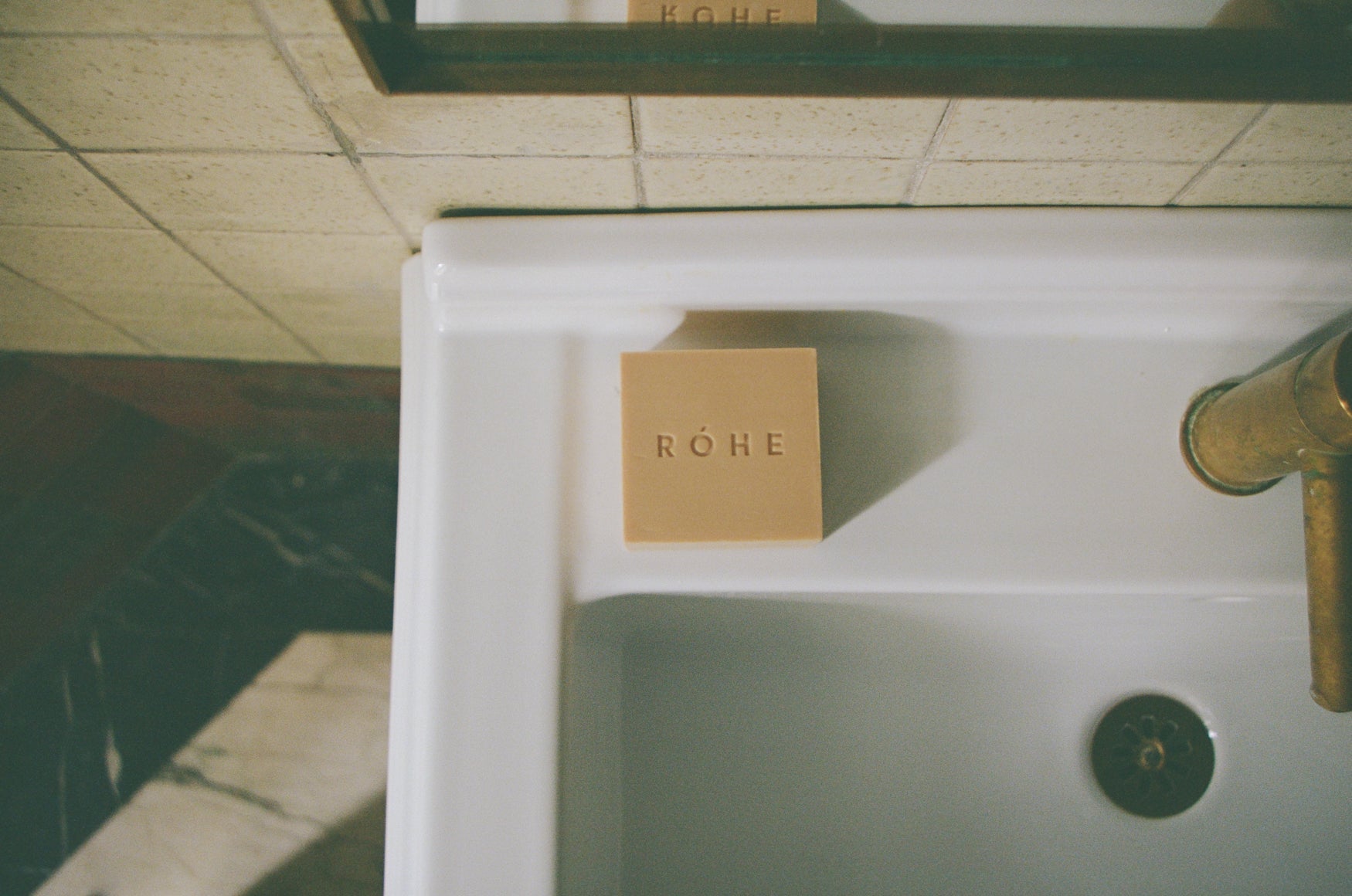 Soap bar with 'Róhe' branding on a sink in a bathroom setting
