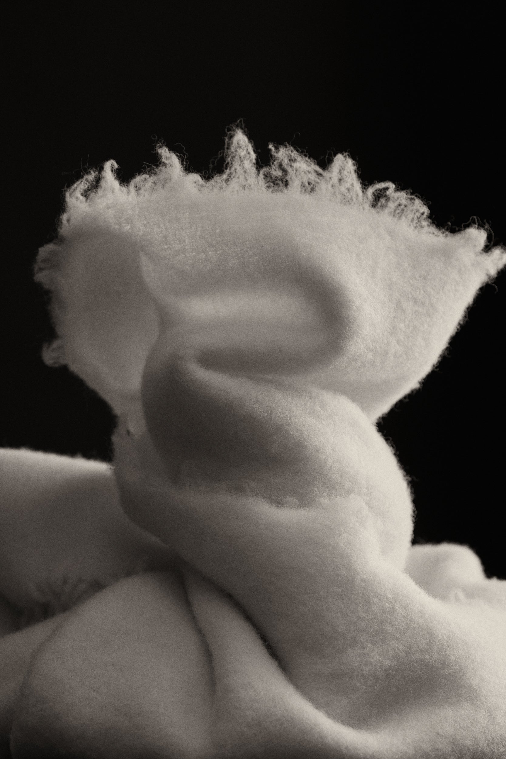 Close-up of a textured cream wool blanket with a black background