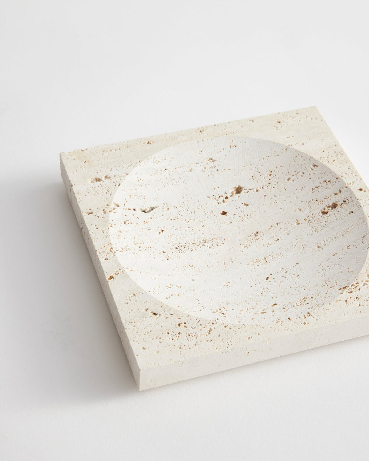 Small tray | travertine: Square stone tray with a round carved indent, handcrafted from leftover Italian travertine by artist Louis Crombag in the Netherlands.