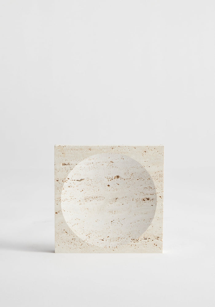 Small tray | travertine: A handcrafted square travertine block with a circular indent, showcasing minimalist design. Made in the Netherlands by artist Louis Crombag.