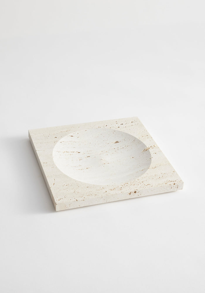 Medium tray | travertine: A handcrafted square stone tray with a central round indent, made from natural Italian travertine by artist Louis Crombag in the Netherlands.