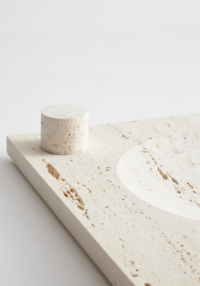 Large tray | travertine: Cream-coloured square tray with round indent and matching cylindrical block for a candle, handcrafted from Italian travertine by Louis Crombag.