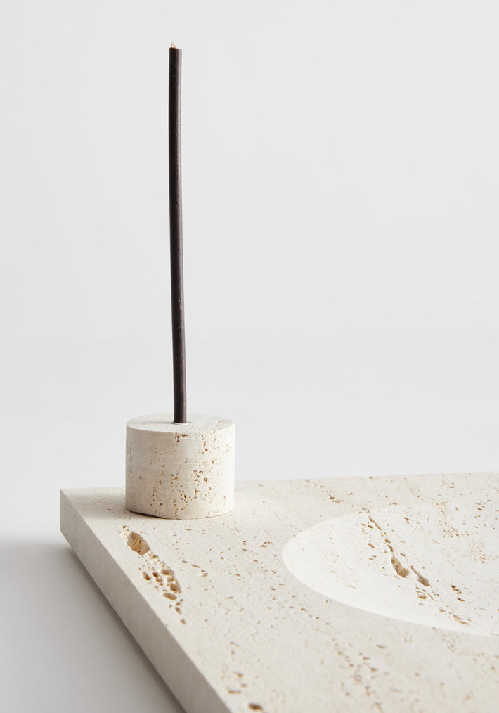 Large tray | travertine: Unlit incense stick in cylindrical stone holder on a square travertine tray with round indent, handcrafted by Dutch artist Louis Crombag.