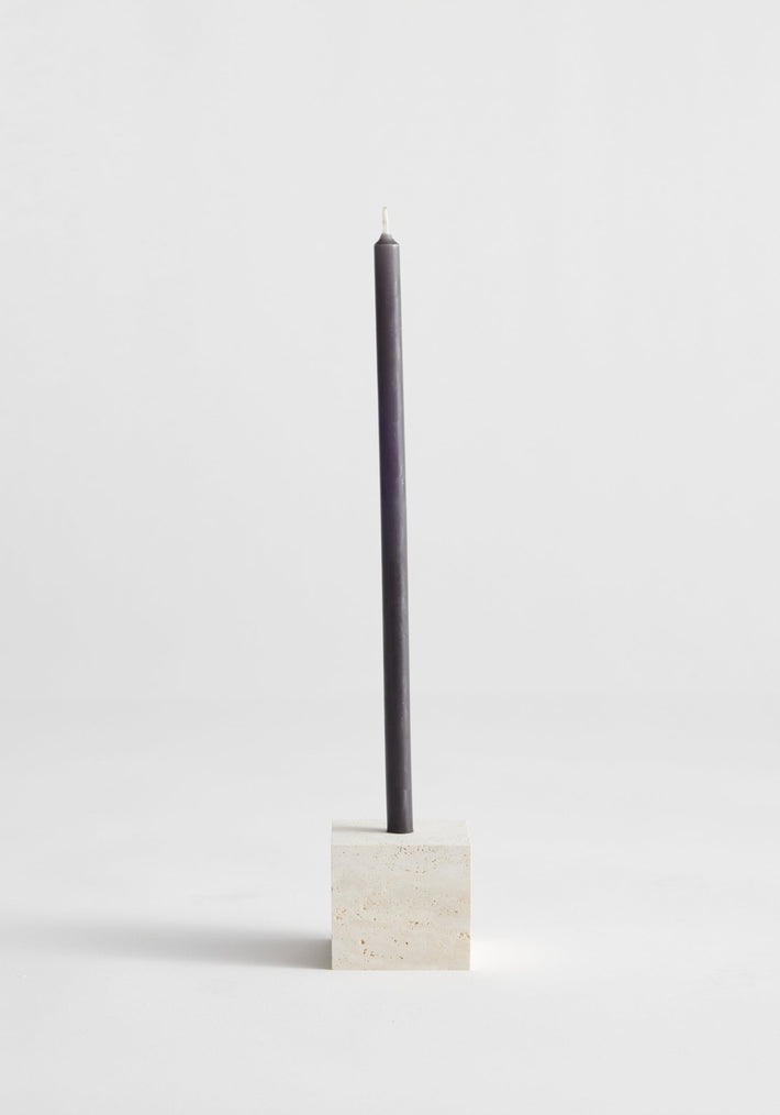 Two-way cube candleholder in travertine, featuring a dark gray taper candle in a beige stone holder, handcrafted by Dutch artist Louis Crombag.