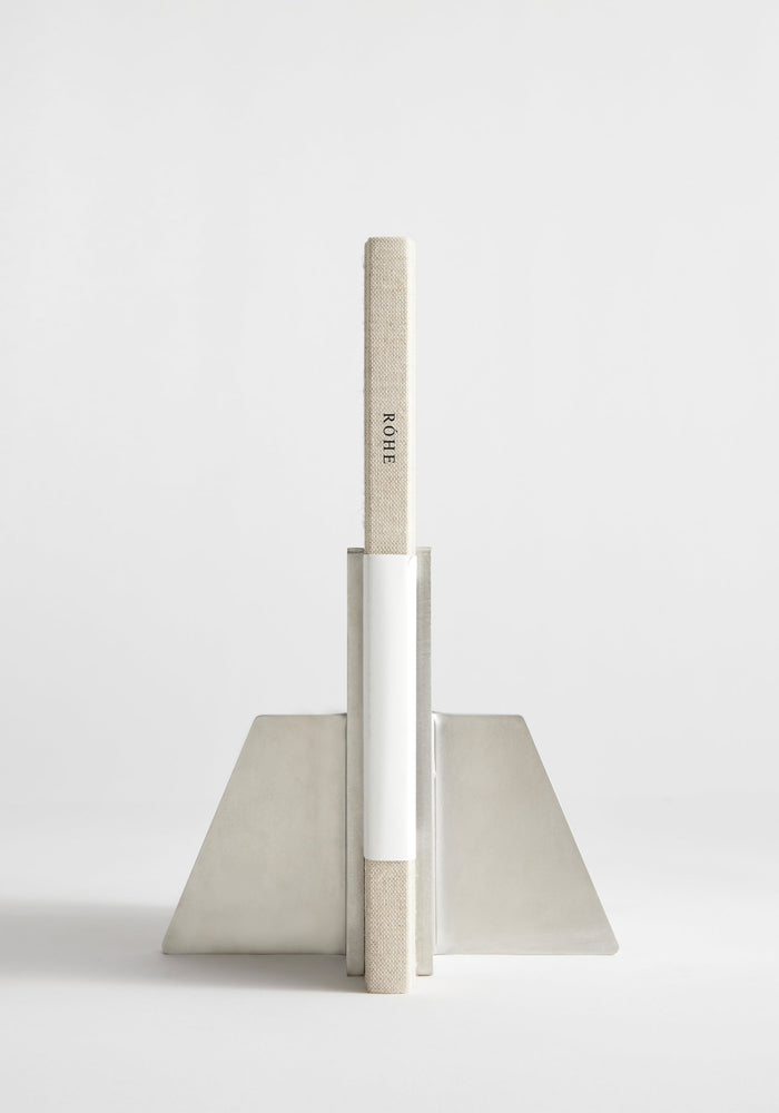 Stainless steel bookends showcasing a single cloth-bound book, ROHE, in an angular, handcrafted design by Paul Coenen, made from 8mm thick stainless steel.