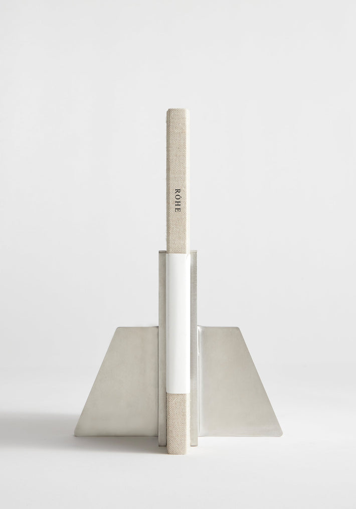 Stainless steel bookends showcasing a single cloth-bound book, ROHE, in an angular, handcrafted design by Paul Coenen, made from 8mm thick stainless steel.