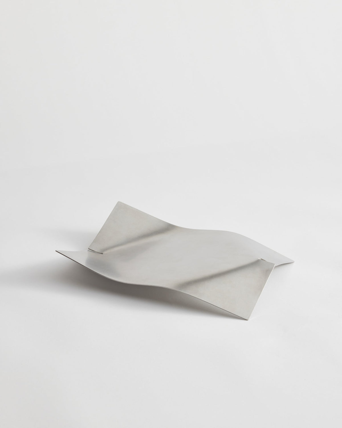 Stainless steel bowl, designed by Paul Coenen, with a wavy, bent form handcrafted in the Netherlands. Made from brushed stainless steel, measuring 32cm x 23.5cm x 5.5cm.