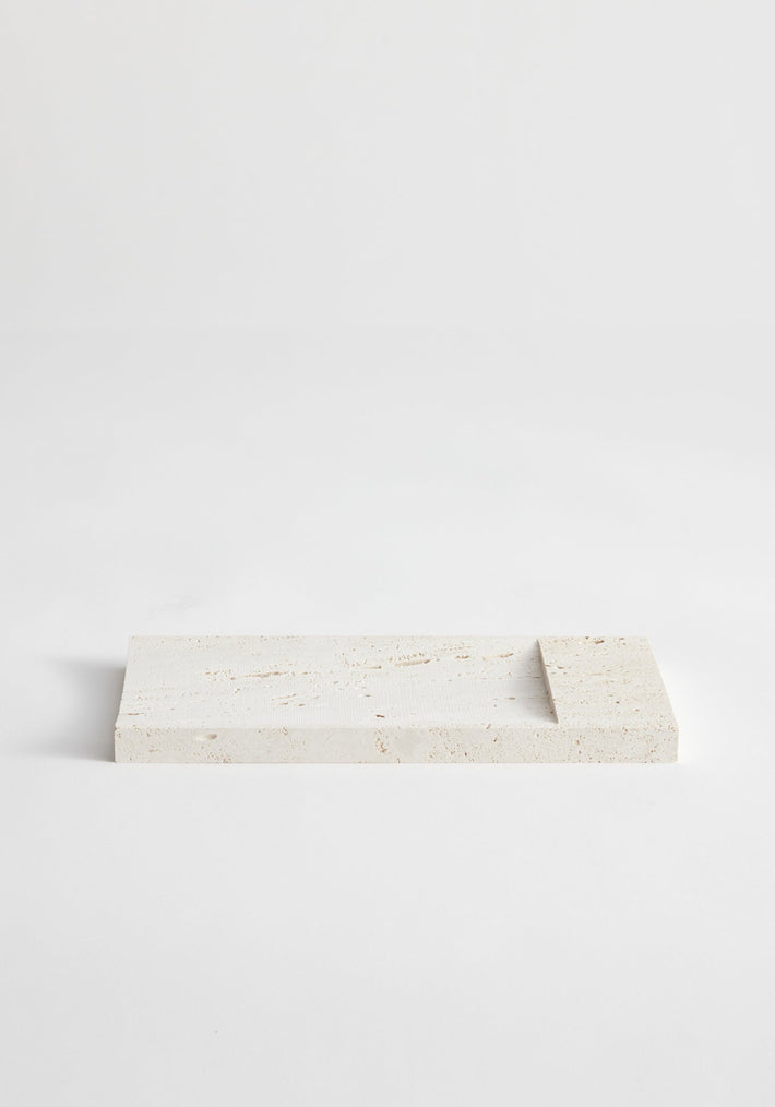 Travertine incense holder tray with a shallow recessed area, handcrafted by Louis Crombag from leftover stone, showcasing a unique speckled pattern.