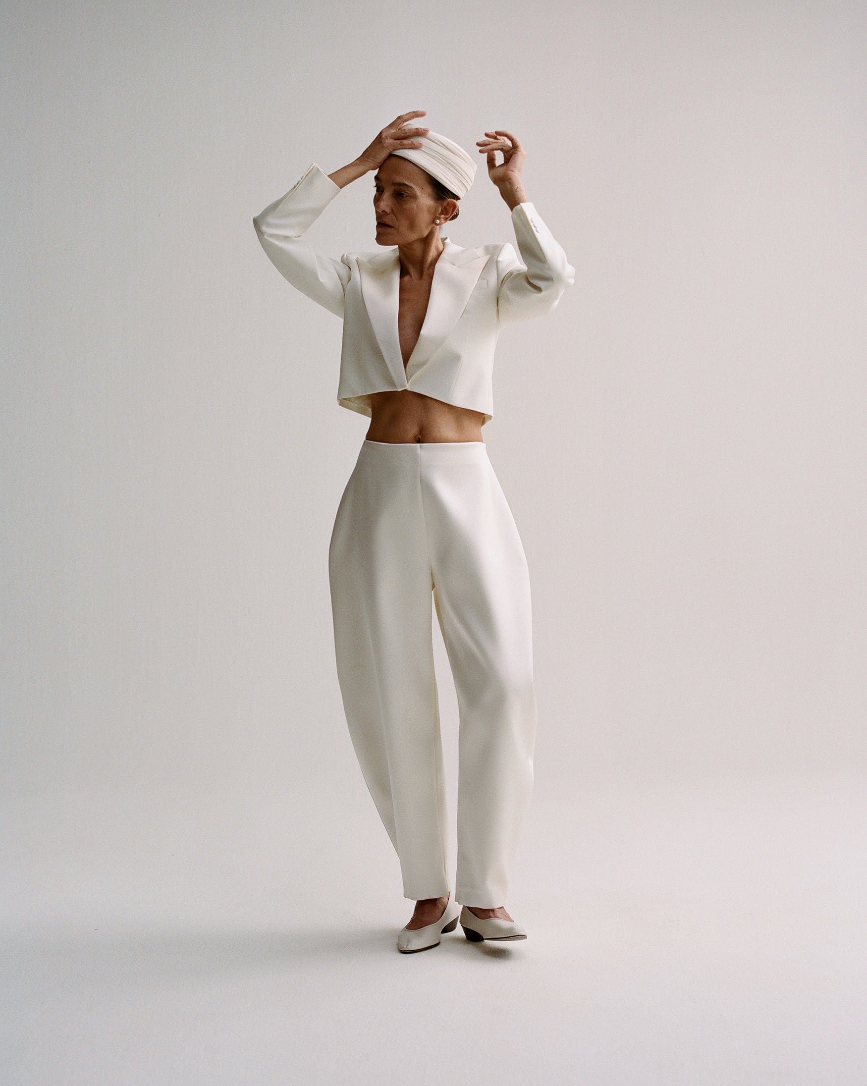 Woman wearing a white suit and white hat.