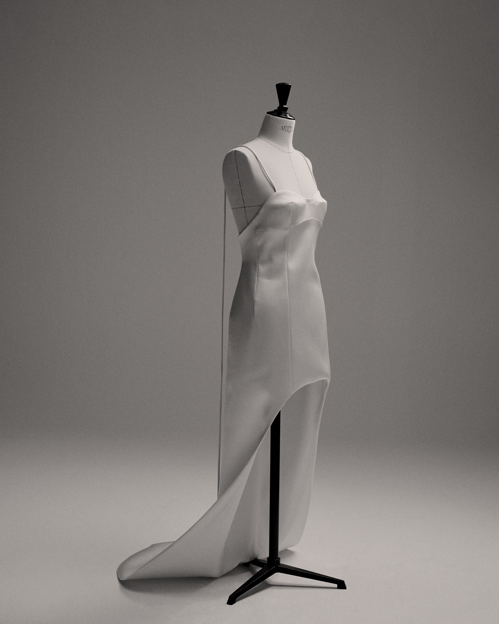 White bustier dress with high low effect on a linen mannequin. 