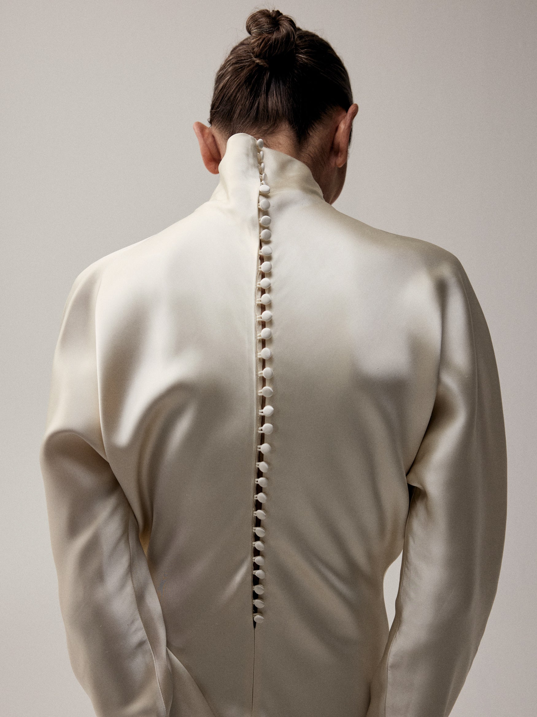 Back of a dress with small buttons going down the middle. 