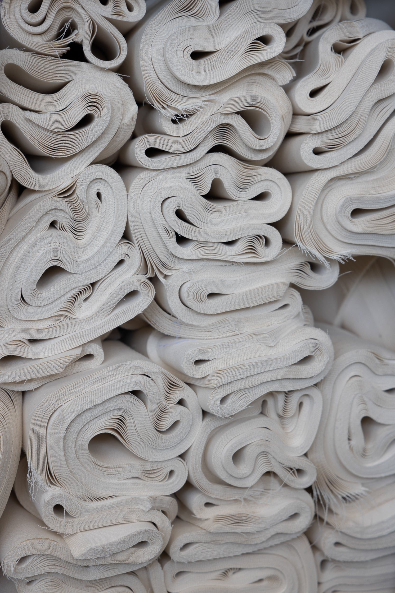 Stack of white fabric strips with wavy edges