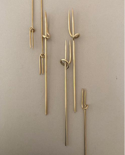 Vine Fork: Handcrafted, gold-tone, two-pronged picks inspired by nature, designed by Misae Nikkei in Kyoto, ideal for skewering appetizers like olives or cheese.