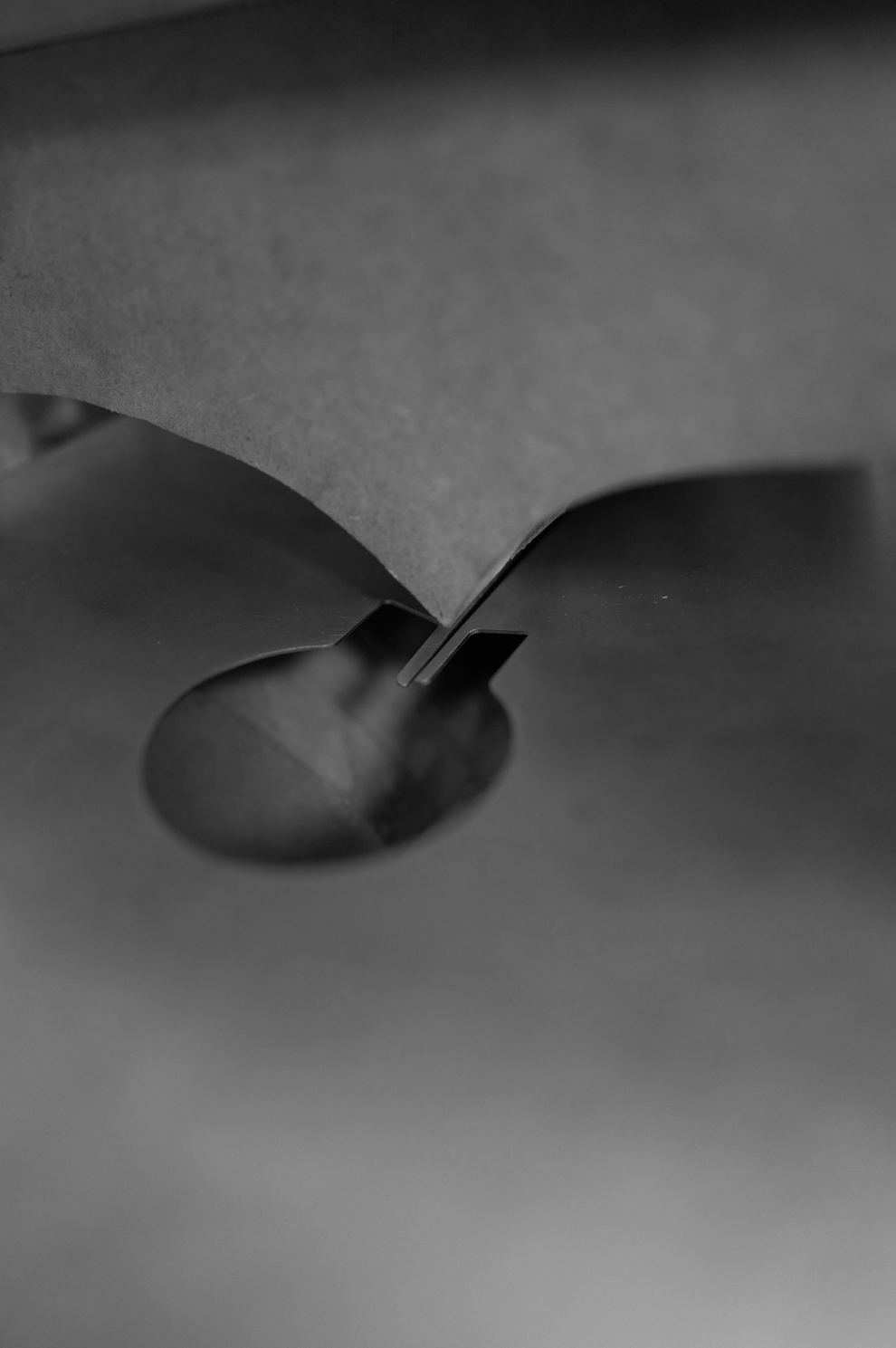 Close-up of a sheet of stainles steel being bent into a sculptural shape