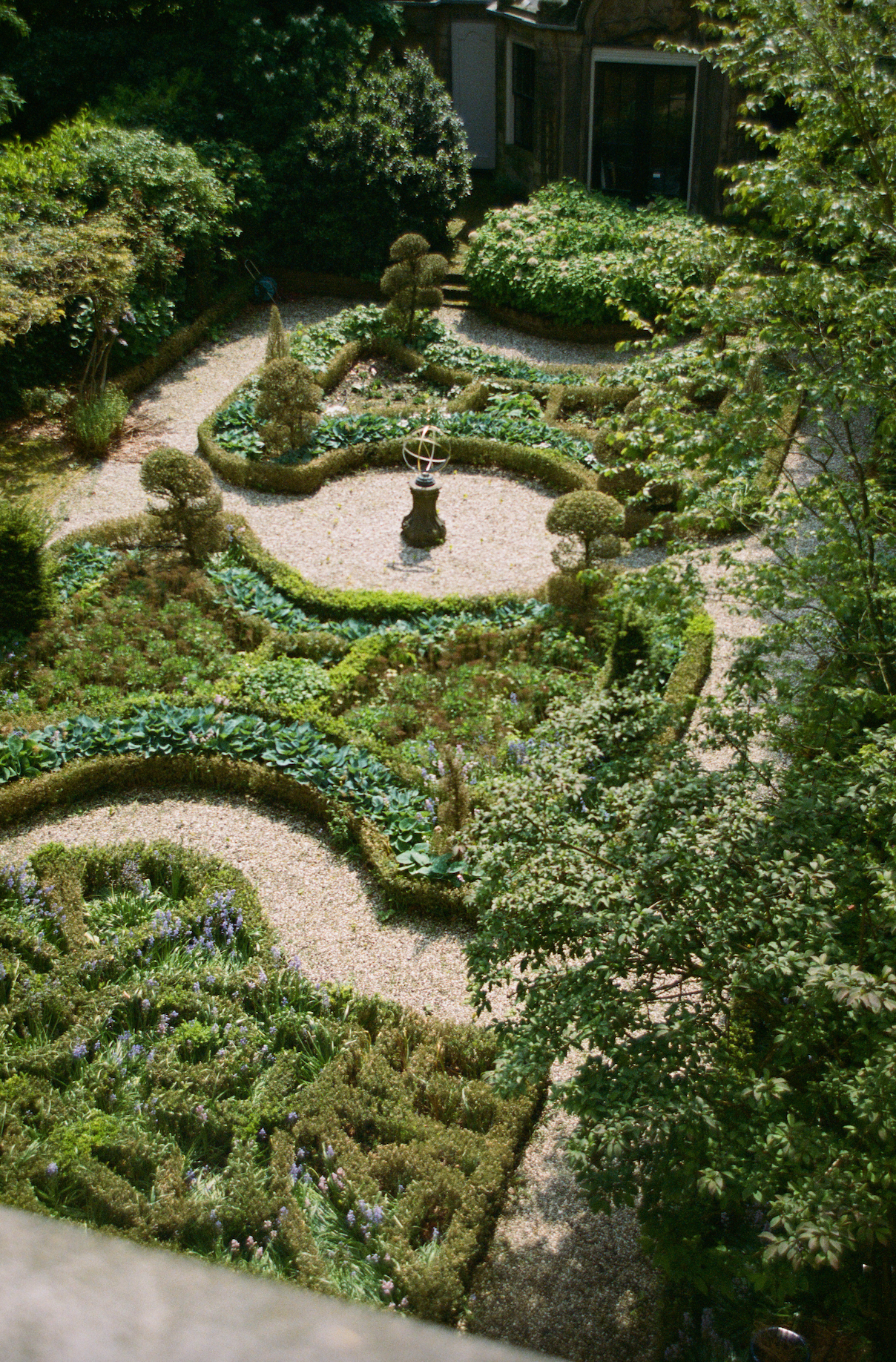 Neatly trimmed garden with a central sculpture surrounded by greenery